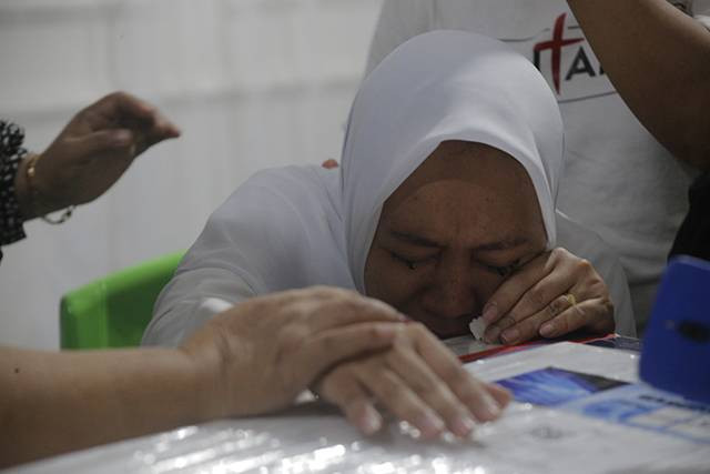 Istri Brigadir Ridhal Ali Tomi menangis histeris di depan peti jenazah yang baru tiba di kediaman mereka di Minahasa, Minggu (28/4). (foto: febry kodongan/manadobacirita)