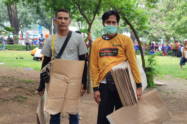 Para penjual tikar di tengah demo buruh di sekitar Patung Kuda, Jakarta Pusat, Rabu (1/5/2024). Foto: Rachmadi Rasyad/kumparan