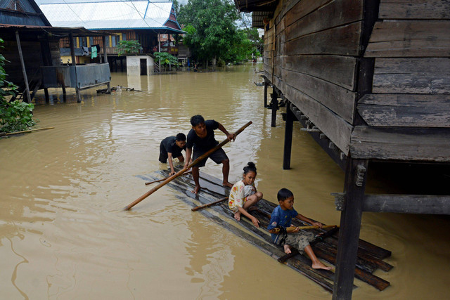Warga menaiki perahu rakit untuk menerobos banjir di Kecamatan Pitu Riawa, Kabupaten Sidenreng Rappang (Sidrap), Sulawesi Selatan, Sabtu (4/5/2024). Foto: Hasrul Said/ANTARA FOTO