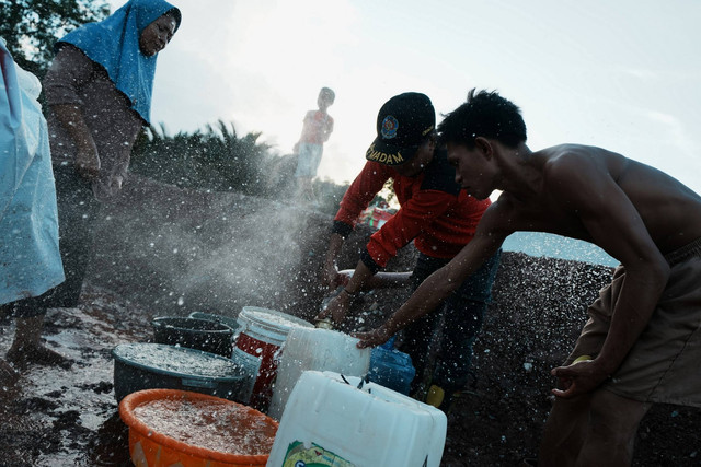 Pengungsi mengisi air bersih yang disediakan pihak Dinas Pemadam Kebakaran di Kecamatan Asera, Konawe Utara, Sulawesi Tenggara, Sabtu (11/5/2024). Foto: Jojon/ANTARA FOTO