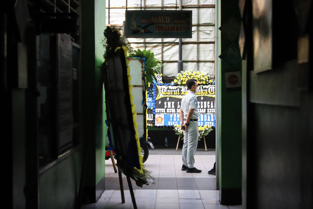 Kendaraan melintasi karangan bunga korban kecelakaan bus Ciater di SMK Lingga Kencana, Depok, Senin (13/5/2024). Foto: Iqbal Firdaus/kumparan