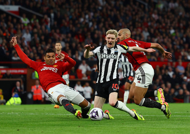 Anthony Gordon diadang Casemiro dan Sofyan Amrabat saat Manchester United vs Newcastle United dalam laga tunda Liga Inggris 2023/24 di Stadion Old Trafford, Kamis (16/5) dini hari WIB. Foto: REUTERS/Molly Darlington