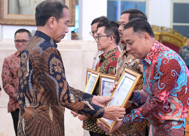 Presiden Jokowi menyerahkan penghargaan Sistem Pemerintahan Berbasis Elektronik (SPBE) terbaik se-Indonesia kepada Wali Kota Surabaya Eri Cahyadi dalam peluncuran GovTech Indonesia dan SPBE Summit 2024 di Istana Negara, Senin (27/5/2024). Foto: Dok. Istimewa
