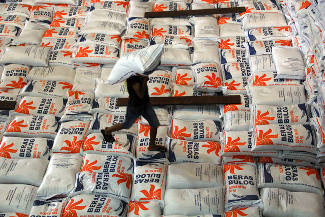 Sejumlah pekerja memikul karung beras di Gudang Bulog, Medan, Sumatera Utara. Foto: Yudi Manar/ANTARA FOTO