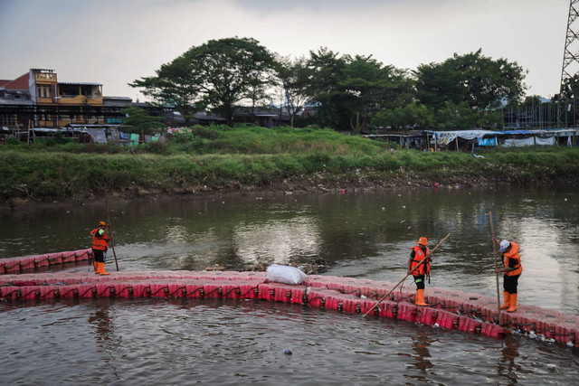 Petugas Unit Pelaksana Kebersihan (UPK) Badan Air Lingkungan Hidup beraktivitas di bantaran Banjir Kanal Barat, Kebon Melati, Tanah Abang Jakarta, Rabu (29/5/2024). Foto: Jamal Ramadhan/kumparan