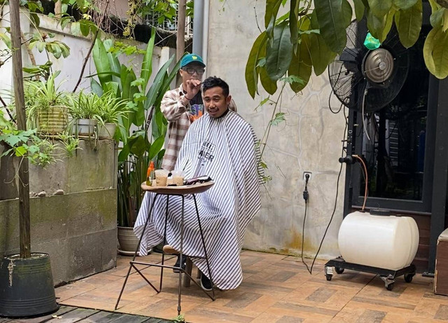 Muhammad Reza saat memangkas rambut pelanggannya di coffe shop. Foto: Yulia Ramadhiyanti/Hi!Pontianak