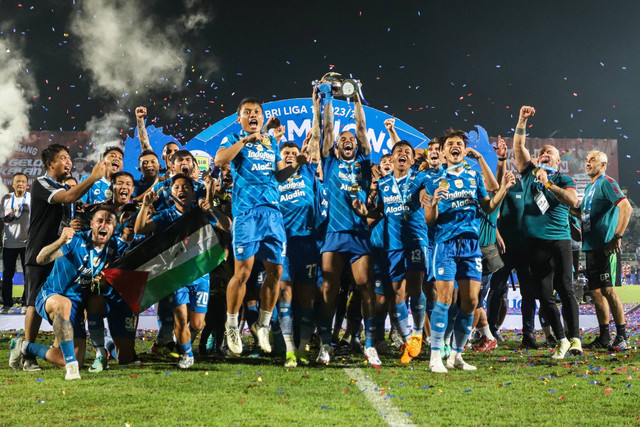 Pesepak bola Persib Bandung dan ofisial tim mengangkat piala usai menjadi juara BRI Liga 1 2023/2024 di Stadion Gelora Bangkalan, Bangkalan, Jawa Timur, Jumat (31/5/2024). Foto: Rizal Hanafi/ANTARA FOTO