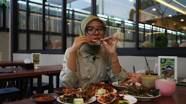 Host program "Diundang Makan" Pandangan Jogja sedang menjajal hidangan di Bebek Goreng H. Slamet by Waroeng Jalan Godean. Foto: Arif UT / Pandangan Jogja