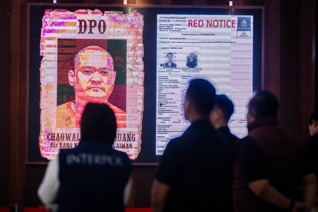 Seorang polisi berada didekat layar yang menampilkan gambar buronan Interpol Thailand Chaowalit Thongduang saat konferensi pers penangkapan buronan Interpol Thailand di Gedung Bareskrim Polri, Jakarta, Minggu (2/6/2024). Foto: Bayu Pratama S/ANTARA FOTO