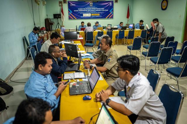 Petugas membantu orang tua murid dan calon peserta didik baru melakukan pengecekan status pendaftaran Penerimaan Peserta Didik Baru (PPDB) di Posko Pelayanan PPDB, Jakarta, Senin (10/6/2024). Foto: Bayu Pratama S/ANTARA FOTO
