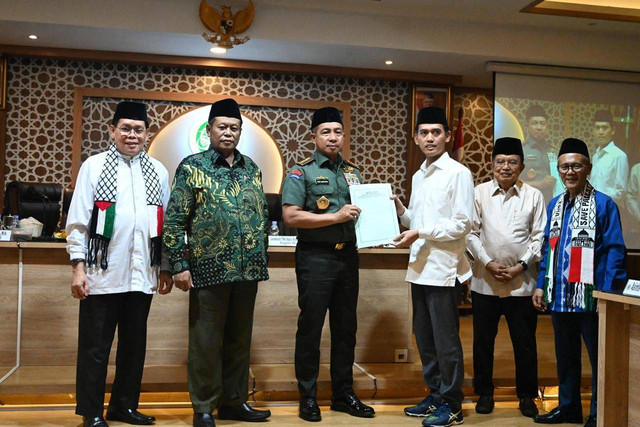 Ketua Bidang Fatwa Majelis Ulama Indonesia (MUI) Asrorun Niam Sholeh (tiga kanan) menyerahkan hasil ijtima ulama kepada Panglima TNI Jenderal Agus Subiyanto (tiga kiri), Jumat (14/6/2024). Foto: Dok. Istimewa