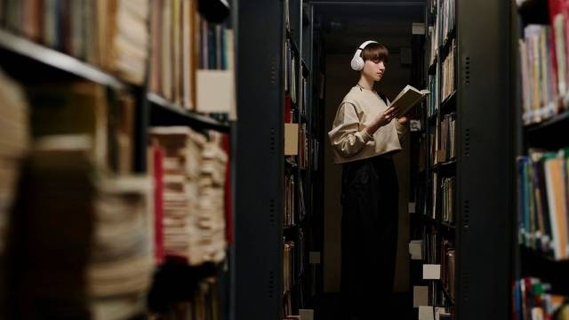 https://www.shutterstock.com/id/image-photo/student-wearing-wireless-headphones-reading-book-2408520487