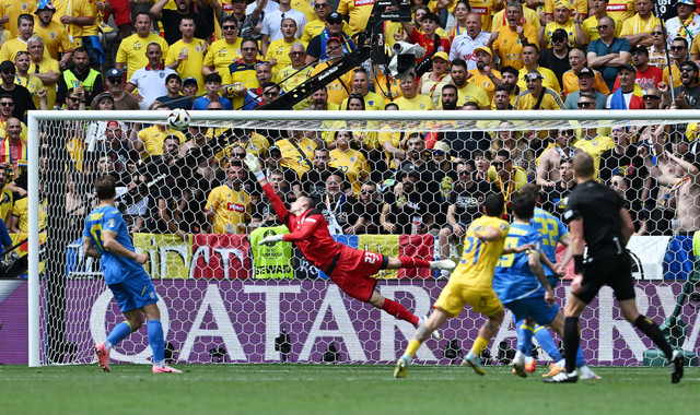 Nicolae Stanciu dari Rumania mencetak gol pertama mereka melewati pemain Ukraina Andriy Lunin REUTERS/pada laga Rumania vs Ukraina, Piala Eropa 2024 di Stadion Allianz Arena, Jerman, Senin (17/6/2024). Foto: Angelika Warmuth/ REUTERS