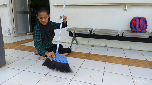 Anak berkebutuhan khusus (ABK) sedang belajar menyapu tanpa bantuan kursi roda (Dokumentasi pribadi)