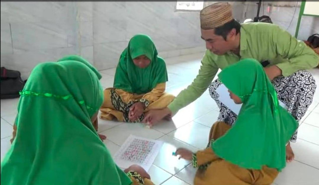 Imam Subawaihin saat mengajar menggunakan permainan ular tangga. Foto: Muhammad Zain/Hi!Pontianak