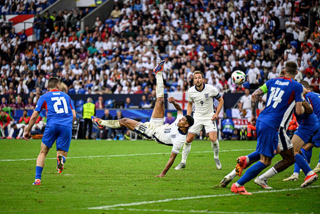 Pemain Timnas Inggris Jude Bellingham mencetak gol ke gawang Timnas Slowakia pada pertandingan 16 besar Piala Eropa 2024 di Veltins-Arena, Jerman, Minggu (30/6/2024). Foto: INA FASSBENDER / AFP