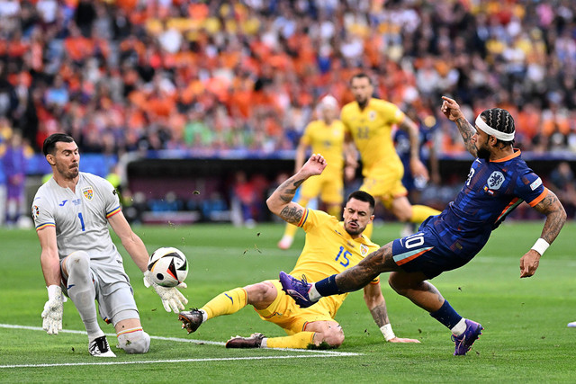 Pemain Timnas Belanda Memphis Depay menendang bola ke arah gawang Timnas Rumania pada pertandingan 16 besar Piala Eropa 2024 di Allianz Arena, Muenchen, Jerman, Selasa (2/7/2024). Foto: Kirill KUDRYAVTSEV/AFP