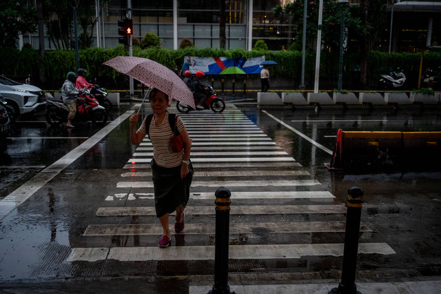 Seorang warga menggunakan payung saat turun hujan di kawasan Bundaran HI, Jakarta, Kamis (4/7/2024). Foto: Erlangga Bregas Prakoso/ANTARA FOTO