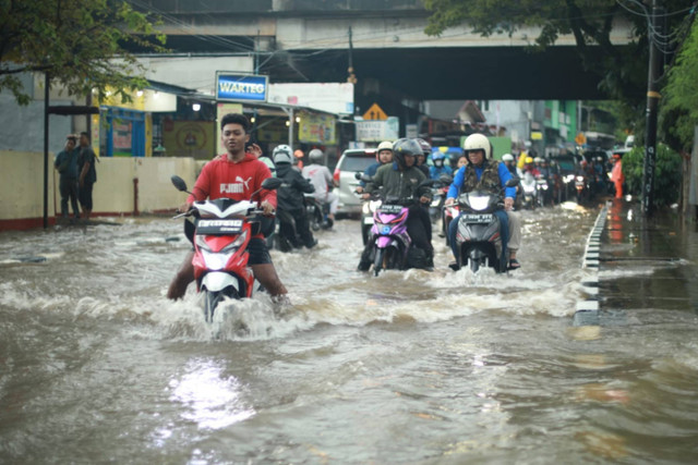Pengendara melintasi banjir setinggi hingga 40 cm akibat luapan Kali Keungan, Pesanggrahan, Jakarta Selatan, Sabtu (6/7/2024). Foto: Aditia Noviansyah/kumparan
