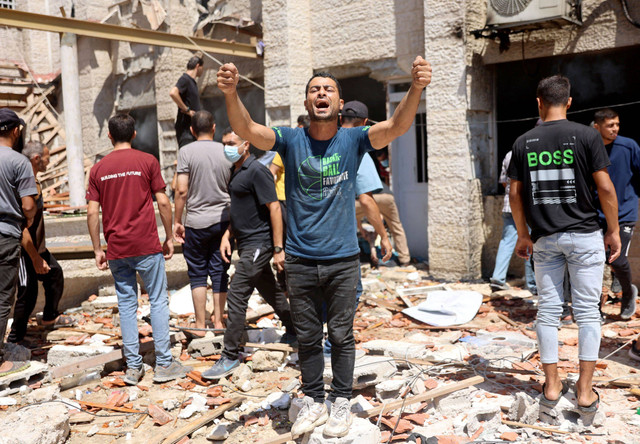 Warga Palestina berdiri di dekat reruntuhan Sekolah Keluarga Suci Patriarkat Latin usai terkena serangan militer Israel di Kota Gaza, Minggu (7/7/2024). Foto: Omar AL-QATTAA / AFP