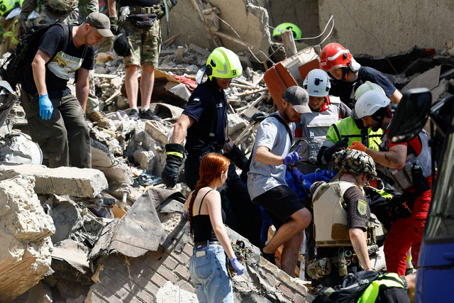 Petugas medis membawa mayat seorang anak di lokasi serangan rudal Rusia di sebuah gedung apartemen, di tengah serangan Rusia ke Ukraina, di Kyiv, Ukraina, Senin (8/7/2024). Foto: VALENTYN OGIRENKO/REUTERS