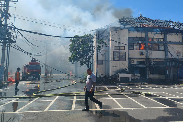 Petugas berupaya memadamkan api yang terus menjalar di Gedung server dan pusat data Universitas Udayana, Kota Denpasar, Selasa (16/7/2024). Foto: Denita BR Matondang/kumparan