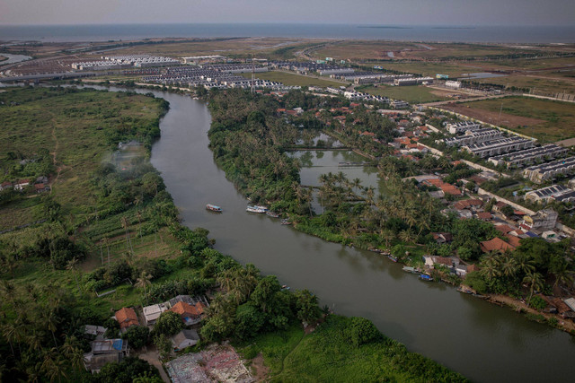 Perahu melintas di Sungai CIsadane dekat pemukiman warga yang bersebelahan dengan Cluster mewah PIK 2 di Tanjung Burung , Kecamatan Teluk Naga, Kabupaten Tangerang, Banten. Foto: Jamal Ramadhan/kumparan