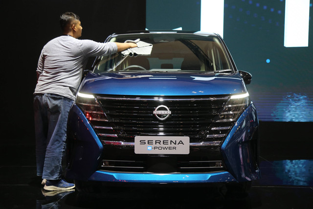Petugas membersihkan mobil Serena e-power saat dipamerkan di GIIAS 2024. Foto: Aditia Noviansyah/kumparan