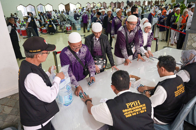 Jamaah haji kloter JKG 63 antre mengambil air zam-zam di Asrama Haji Pondok Gede, Jakarta, Minggu (21/7/2024). Foto: ANTARA FOTO/Sigid Kurniawan