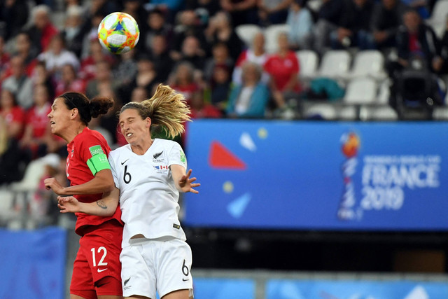 Pemain Timnas Wanita Kanada Christine Sinclair berebut bola dengan pemain Timnas Wanita Selandia Baru Rebekah Stott pada pertandingan Grup E Piala Dunia Wanita Prancis 2019 di Stadion Alpes di Grenoble, Prancis, pada 15 Juni 2019. Foto: Jean-Pierre Clatot / AFP