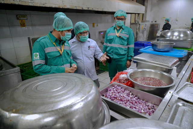 Human Resource & General Affair (HRGA) Superintendent Harita Nickel, Junaidi Arief (kiri) memantau bahan makanan untuk karyawan di area dapur kantin Harita Nickel. Foto: Jamal Ramadhan/kumparan