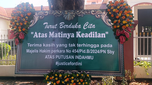 Karangan bunga terpasang di PN Surabaya yang diduga ditujukan kepada hakim yang vonis bebas Gregorius Ronald Tannur (31), kasus penganiayaan kekasihnya hingga tewas, Jumat (26/7/2024). Foto: Farusma Okta Verdian/kumparan