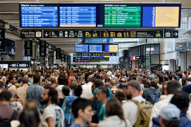 Sejumlah penumpang kereta cepat SNCF menunggu kedatangan kereta saat kereta cepat dilanda kejahatan vandalisme di Stasiun kereta api Strasbourg, Prancis, Jumat (26/7/2024). Foto: Abdesslam MIRDASS / AFP