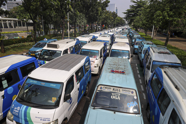 Ratusan mobil JakLingko dan mikrolet terparkir saat melakukan aksi unjuk rasa di depan Balai Kota, Jakarta pada Selasa (30/7/2024). Foto: Iqbal Firdaus/kumparan