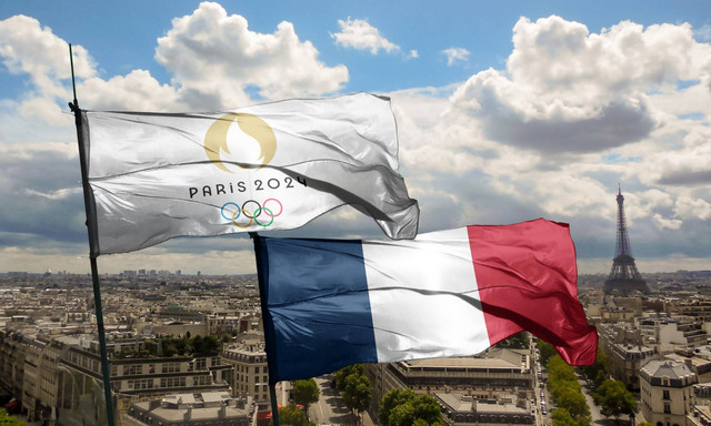 Bendera Olimpiade Paris 2024 bersanding dengan bendera Perancis di tengah kota Paris. Foto: Shutterstock.