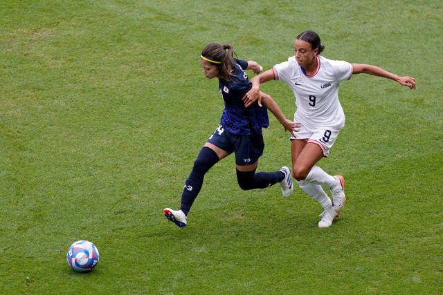 Pemain Timnas Wanita Jepang Yui Hasegawa berebut bola dengan pemain Timnas Wanita Amerika Serikat Mallory Swanson pada pertandingan perempat final Olimpiade Paris 2024 di Parc des Princes, Paris, Prancis, Sabtu (3/8/2024). Foto: Geoffroy VAN DER HASSELT / AFP