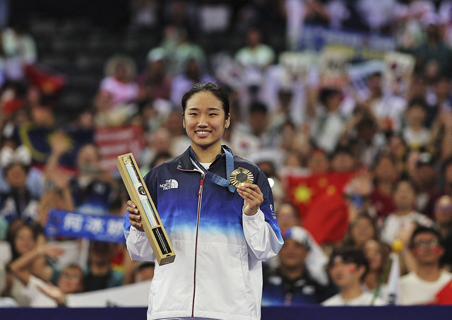 Peraih medali emas pada cabang olahraga bulu tangkis tunggal putri pada Olimpiade Paris 2024 Se Young An dari Korea Selatan berpose dengan medalinya saat upacara Senin (5/8/2024). Foto: Ann Wang/REUTERS