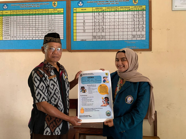 Penyerahan poster kepada kepala sekolah SDN 3 Basuhan