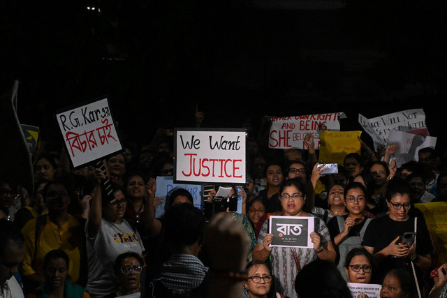 Para profesional medis dan aktivis memegang poster dan lilin ketika mereka mengambil bagian dalam protes tengah malam untuk mengutuk pemerkosaan dan pembunuhan seorang petugas medis muda, di Kolkata pada tanggal 14 Agustus 2024. Foto: Dibyangshu SARKAR/AFP