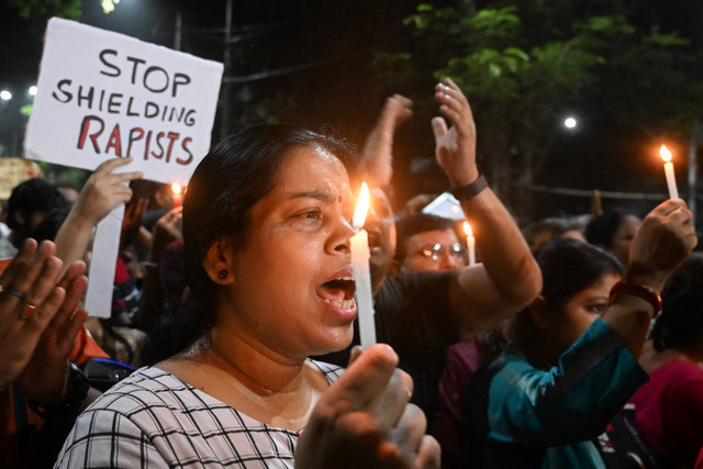 Para profesional medis dan aktivis memegang poster dan lilin ketika mereka mengambil bagian dalam protes tengah malam untuk mengutuk pemerkosaan dan pembunuhan seorang petugas medis muda, di Kolkata pada tanggal 14 Agustus 2024. Foto: Dibyangshu SARKAR/AFP