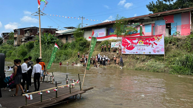 Warga Medan menonton upacara HUT ke-79 RI di Kampung Aur, Medan. Foto: Tri Vosa/kumparan