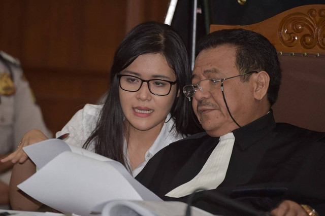 Jessica Kumala Wongso (kiri) berbicara dengan pengacaranya Otto Hasibuan (kanan) selama persidangan di pengadilan Jakarta Pusat di Jakarta pada tanggal 26 September 2016. Foto: Adek Berry/AFP