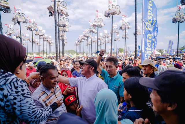 Cagub Sumsel, Herman Deru (kemeja putih) saat disambut antusias masyarakat dalam perlombaan panjat pinang di Palembang. (ist)