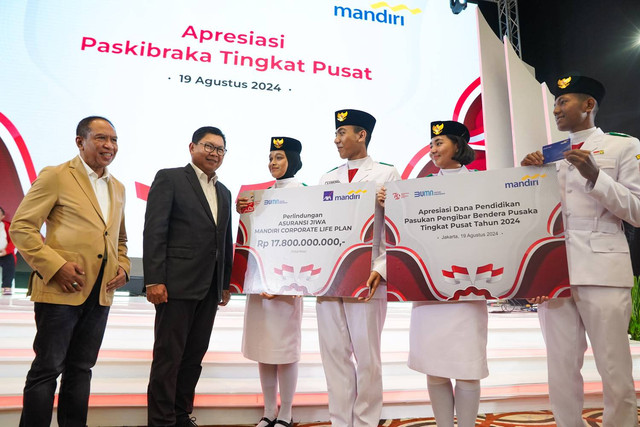 Direktur Utama Bank Mandiri, Darmawan Junaidi (kiri kedua) menyerahkan apresiasi kepada Paskibraka Tingkat Pusat peringatan HUT ke-79 RI di Jakarta, Senin (19/8/2024). Foto: Dok. Bank Mandiri