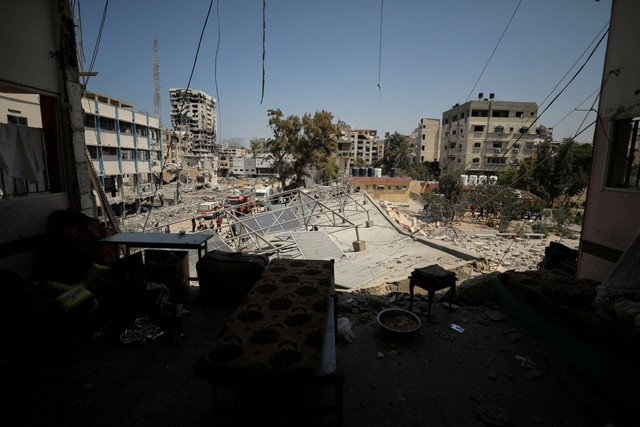 Warga Palestina memeriksa sekolah yang menampung pengungsi setelah terkena serangan udara Israel di Kota Gaza, Selasa (20/8/2024). Foto: Dawoud Abu Alkas/REUTERS