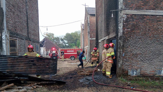 Petugas saat lakukan pemadaman kebakaran gudang pengeringan tembakau (oven) di Desa Trate, Kecamatan Sugihwaras, Kabupaten Bojonegoro. Senin (02/09/2024). (Aset: Istimewa)