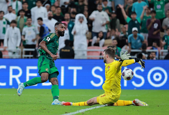 Penyerang Arab Saudi Feras Al Brikan berduel dengan penjaga gawang Indonesia Maarten Paes dalam pertandingan ronde tiga di King Abdullah Sports City, Jeddah, Arab Saudi, Jumat (6/8/2024). Foto: Stringer/Reuters