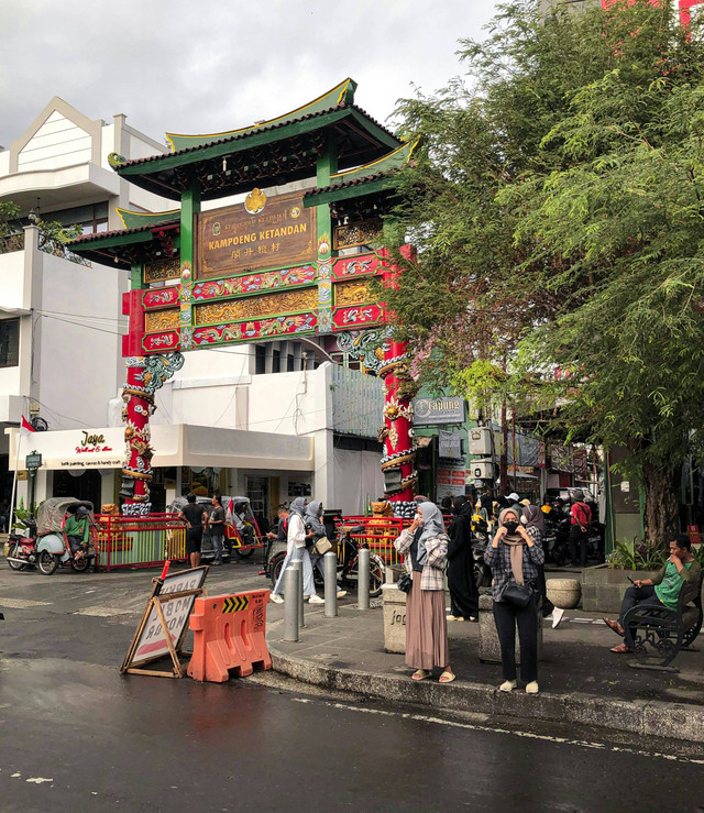 Sebuah pecinan di Yogyakarta. Tampak sekumpulan perempuan berhijab sedang berlalu lalang di depan gerbang pecinan. Hal tersebut menjadi potret toleransi dan kebersamaan antargolongan, dalam hal ini umat Islam dan masyarakat Tionghoa. Foto: Mardanafin.