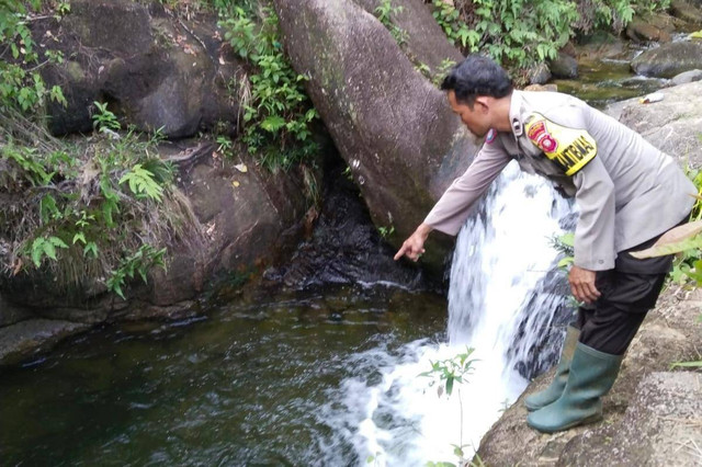 Personel Polres Ketapang menunjukkan tempat tenggelamnya korban di air terjun Batu Hitam. Foto: Dok. Polres Ketapang