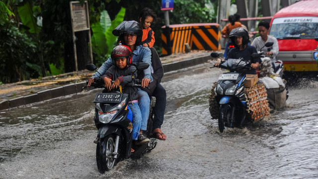 Pengendara roda dua menerobos genangan air akibat hujan lebat di Rangkasbitung, Lebak, Banten, Jumat (13/9/2024). Foto: Muhammad Bagus Khoirunas/ANTARA FOTO